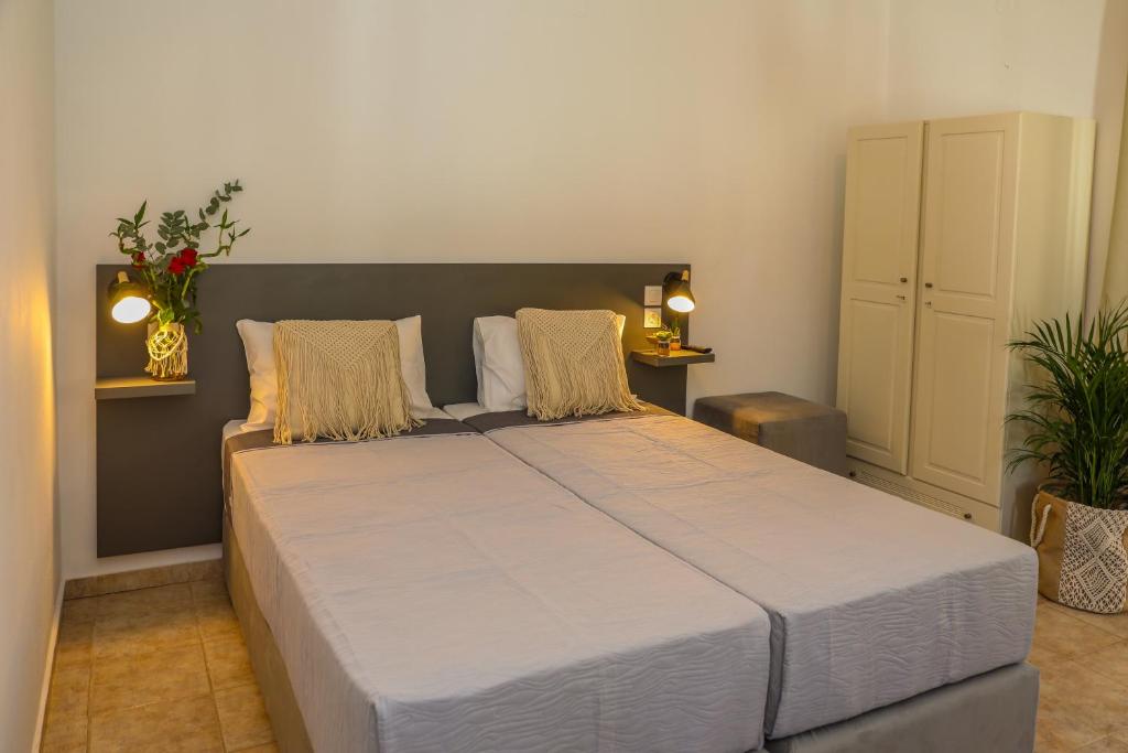 ein Schlafzimmer mit einem großen weißen Bett mit zwei Kissen in der Unterkunft La FLEUR apartments in Skiathos-Stadt