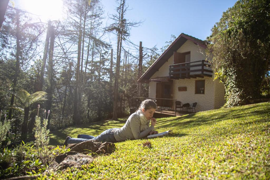 a young girl laying on the grass in the yard at Pousada Aguia da Montanha in Monte Verde