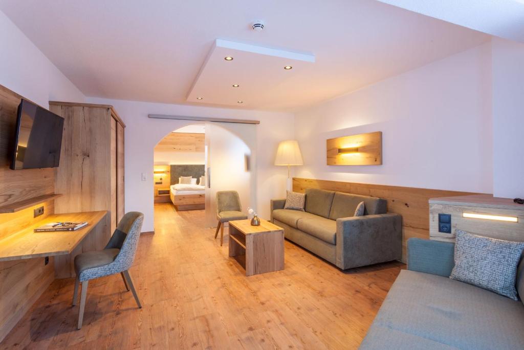 ein Wohnzimmer mit einer Couch und einem Tisch in der Unterkunft Hotel Luggi in Galtür