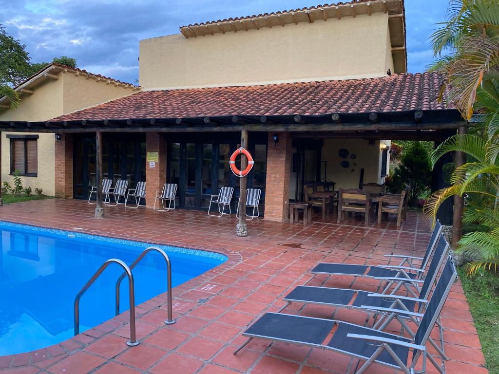 uma casa com piscina em frente a uma casa em Finca Panaca Jaguey 5 em Quimbaya