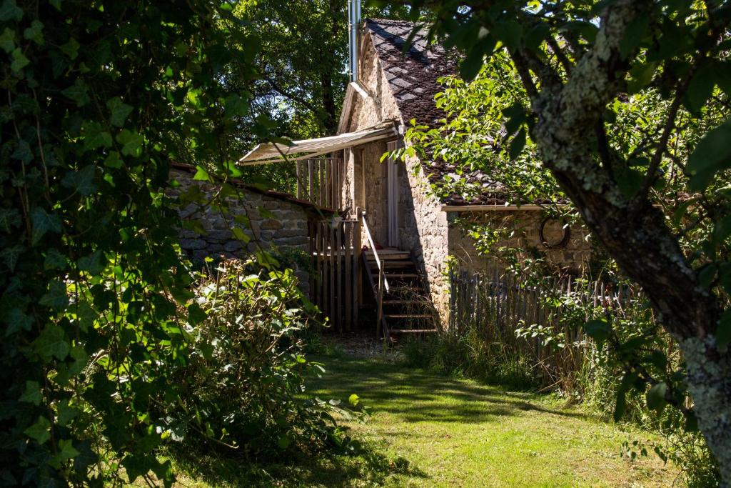 Cette ancienne maison en pierre est dotée d'une porte en bois et d'escaliers. dans l'établissement '' Gite Q'uatre '' Charlannes, à Hautefage