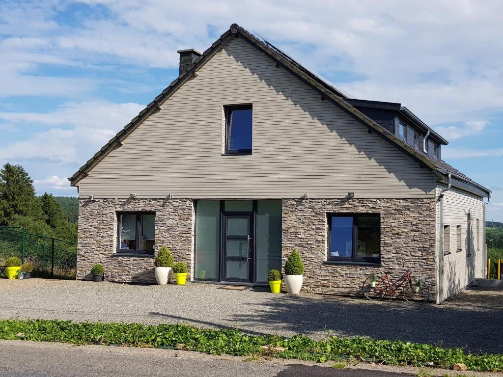 a stone house with two windows and two potted plants at Gite le Ravel in Hockai