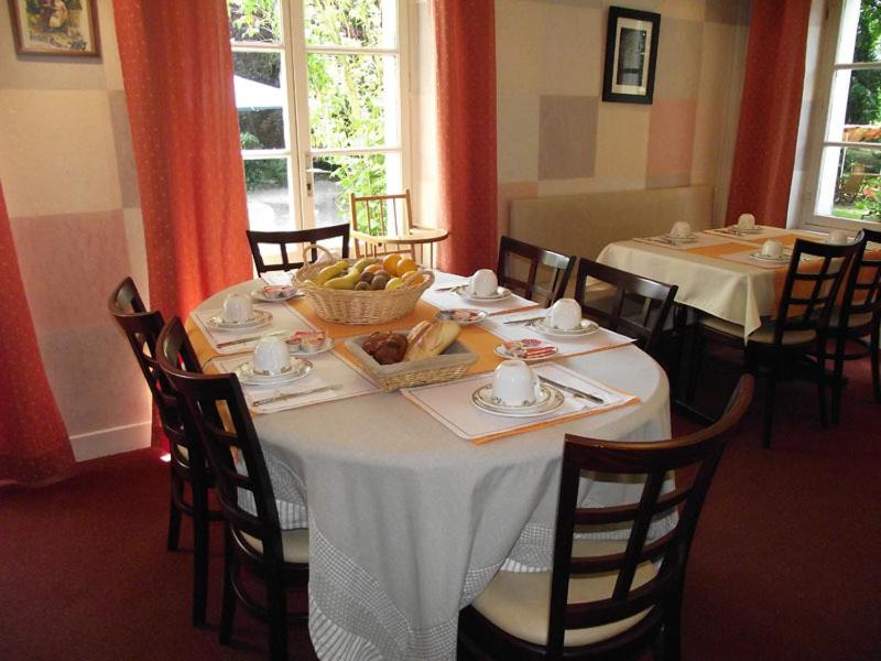 a dining room with a table with a bowl of fruit at Cit&#39;Hotel Avallon Vauban in Avallon