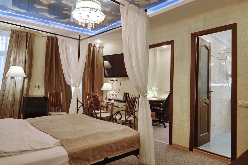 - une chambre avec un lit, une table et des chaises dans l'établissement Skyview City, à Moscou