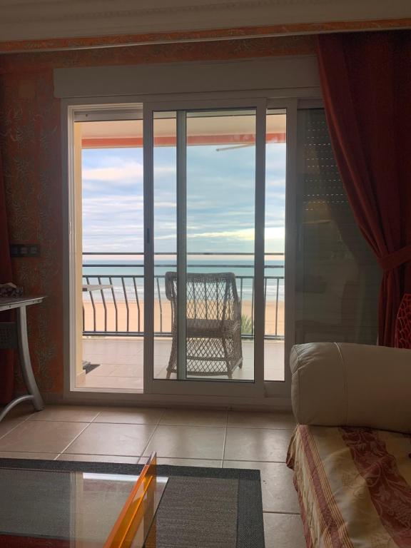 ガンディアにあるMagnificos Apartamentos Ondina en la Primera Linea de la Playa de Gandiaの海の景色を望むガラスのスライドドアが備わる客室です。
