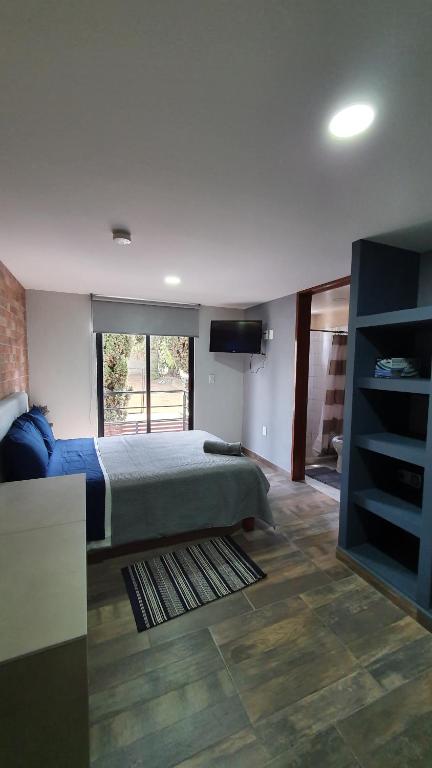 a bedroom with a bed and a flat screen tv at R08 LUXURY STUDIO RAISE a 5 MIN DEL ITESM R08 in Mexico City