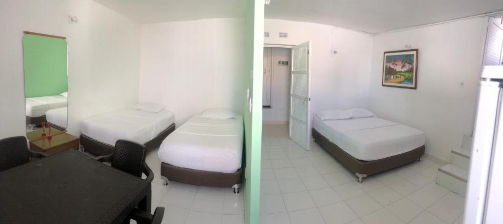 a room with two beds and a room with a room with at Edificio águila in San Andrés