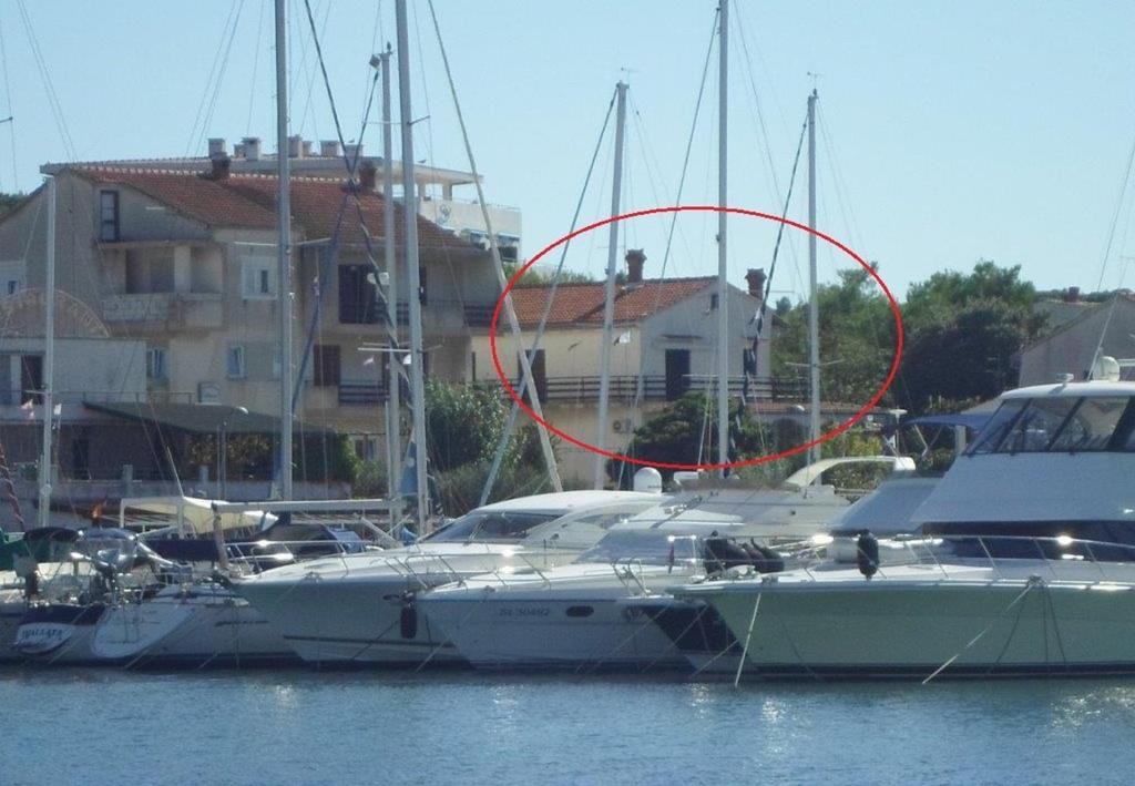 um barco na água com um círculo vermelho sobre ele em Apartments Matija - 30m from sea em Jezera