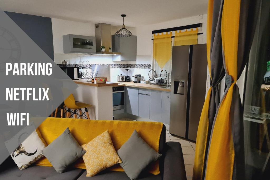 a kitchen and a living room with a yellow couch at Le Nid Dor - Appartement de standing in Le Gosier