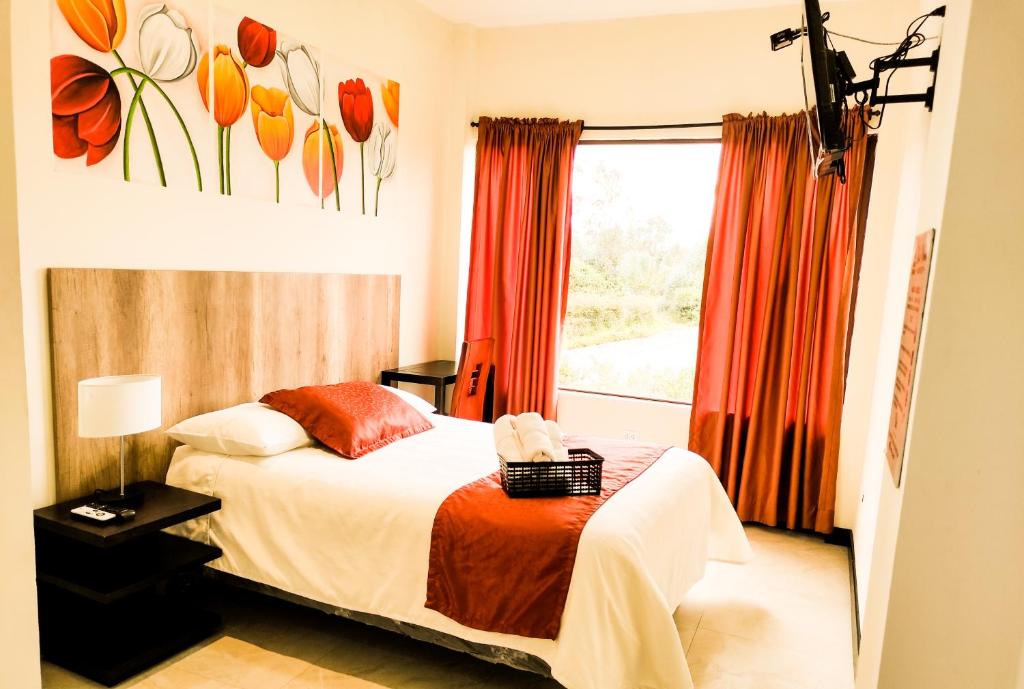 um quarto com uma cama e uma janela em Hotel Las Mercedes Airport-Quito em Tababela