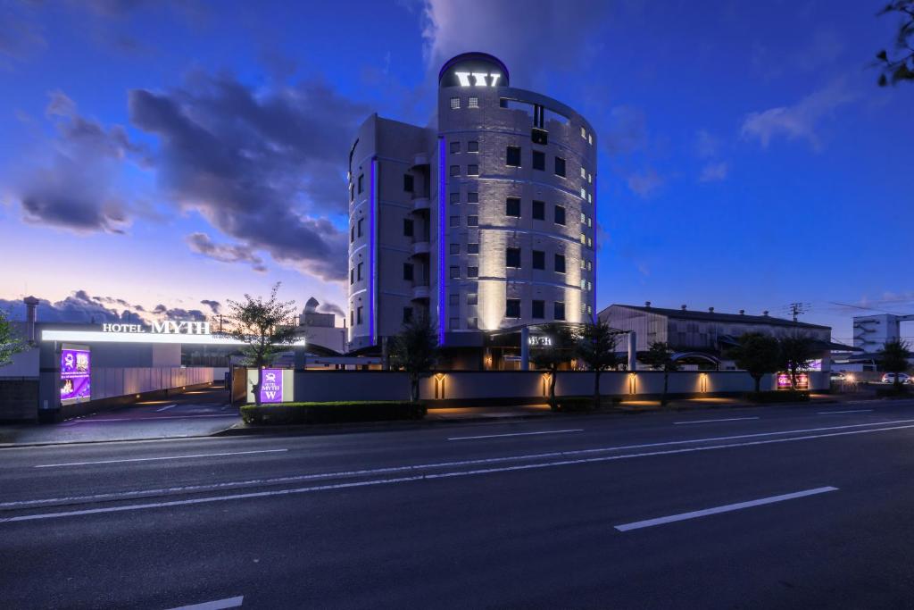 ein Gebäude mit einem Uhrenturm am Straßenrand in der Unterkunft HOTEL MYTH-W -ホテル マイス ダブリュー- adult only in Sakaide