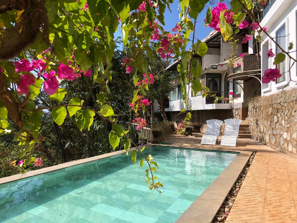 uma piscina em frente a uma casa com flores cor-de-rosa em Homestay Thác Liên Khương em Ðưc Trọng