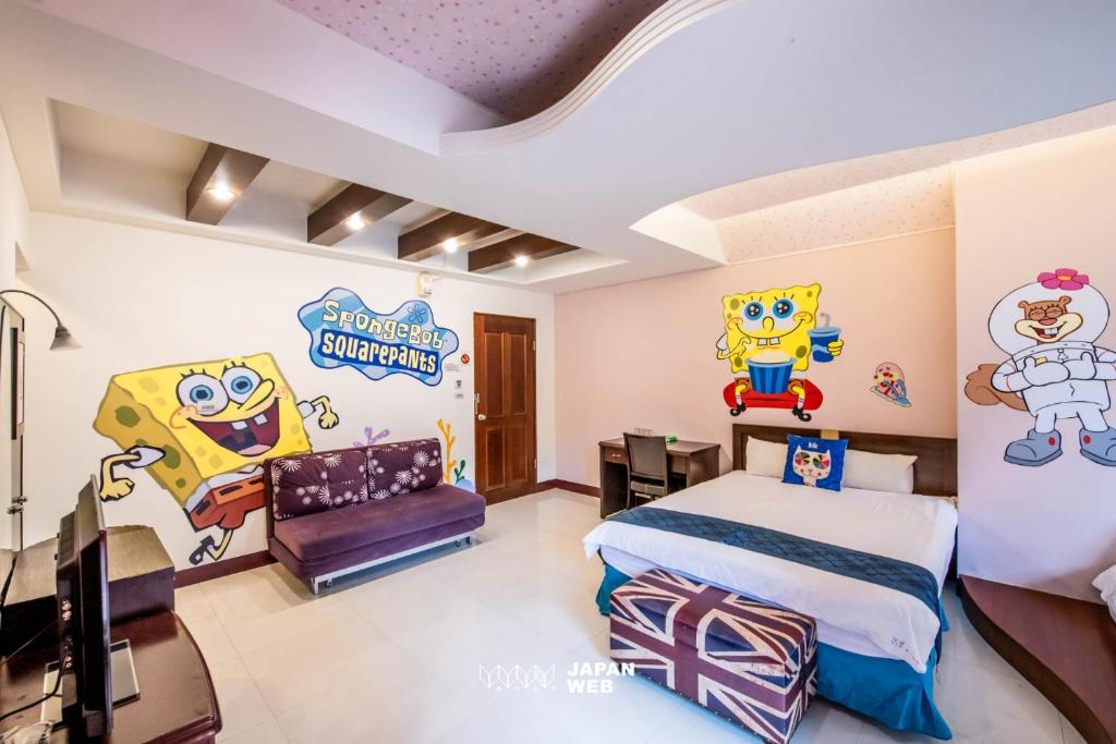 a bedroom with a bed with cartoon characters on the walls at Ribbed Birch B&amp;B in Hualien City