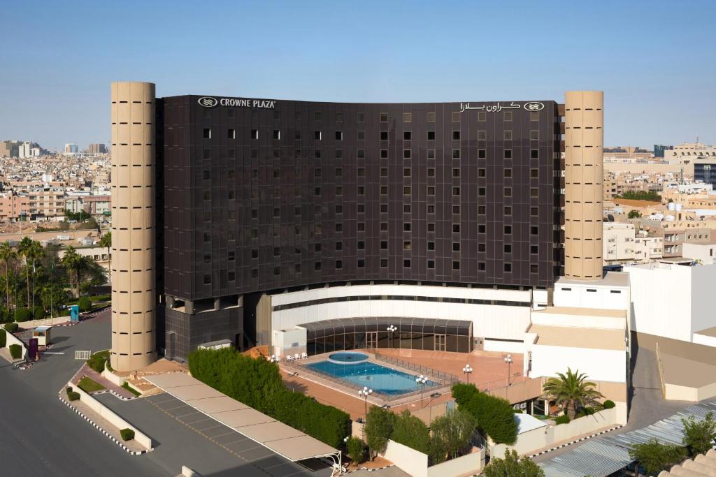 ein Hotel mit einem Schwimmbad vor einem Gebäude in der Unterkunft Crowne Plaza Riyadh Palace by IHG in Riad