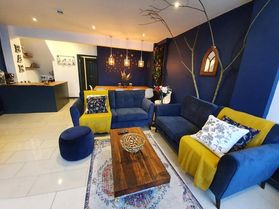 a living room with blue couches and a table at Enchanted Hideaway, Bath in Bath