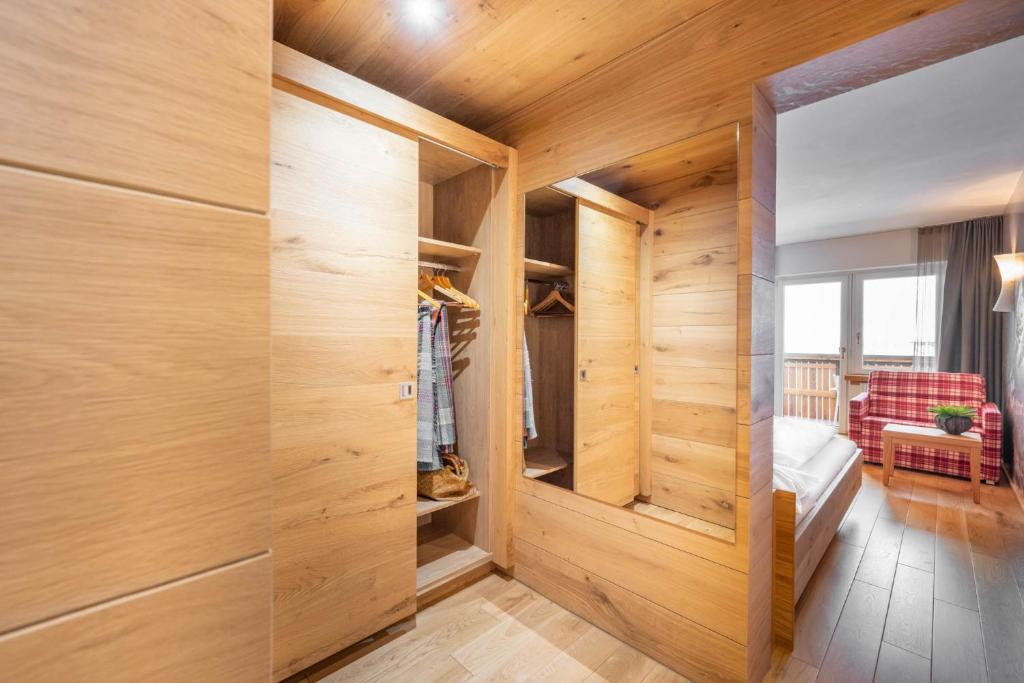 a bedroom with wooden walls and a closet at Sporthotel Silvretta Montafon in Gaschurn