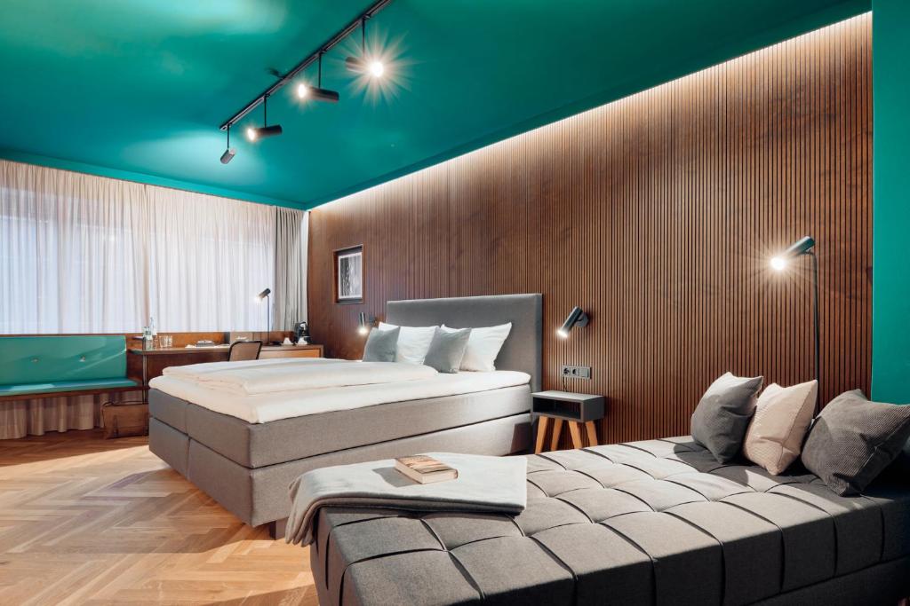 pokój hotelowy z 2 łóżkami i kanapą w obiekcie art Hotel Tucholsky w mieście Bochum