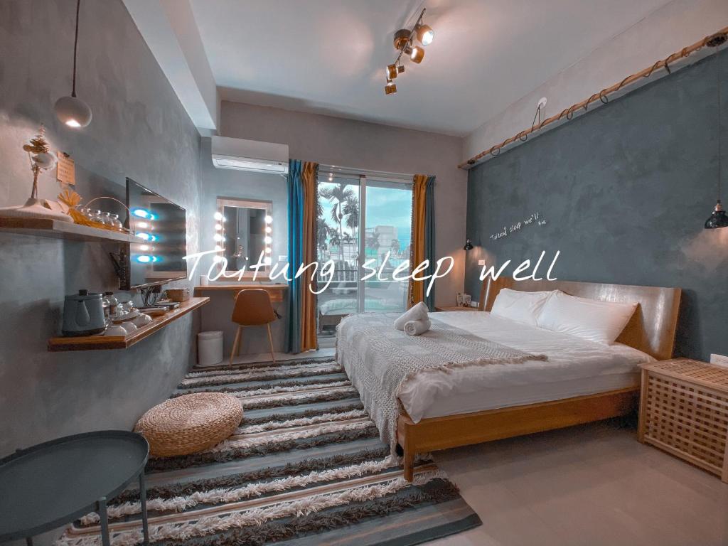 台東市的住宿－東眠 Taitung sleep well，一间卧室配有一张蓝色墙壁的床