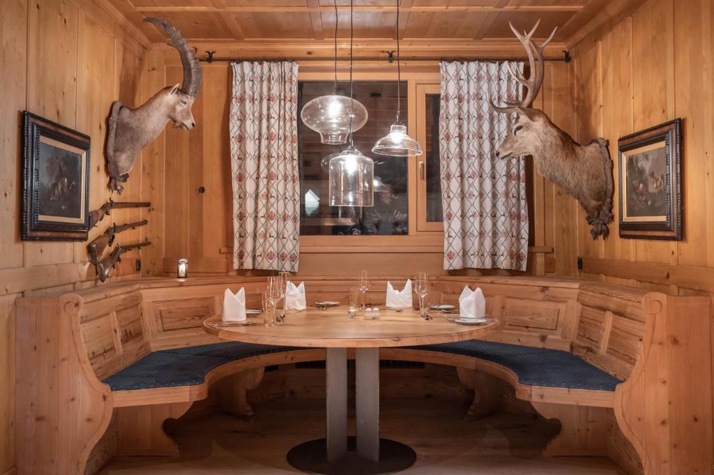 a dining room with a table with antlers on the wall at Sporthotel Silvretta Montafon in Gaschurn