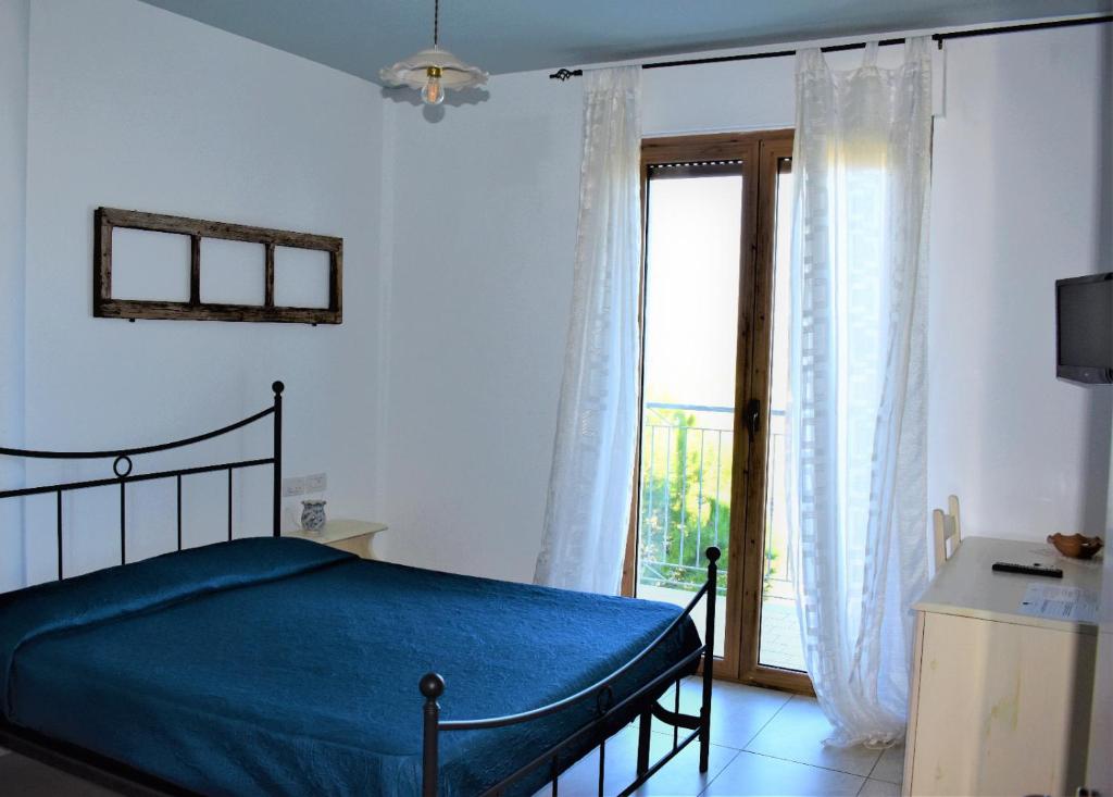 a bedroom with a bed and a large window at Casolare Azzurro in Acquaviva Picena