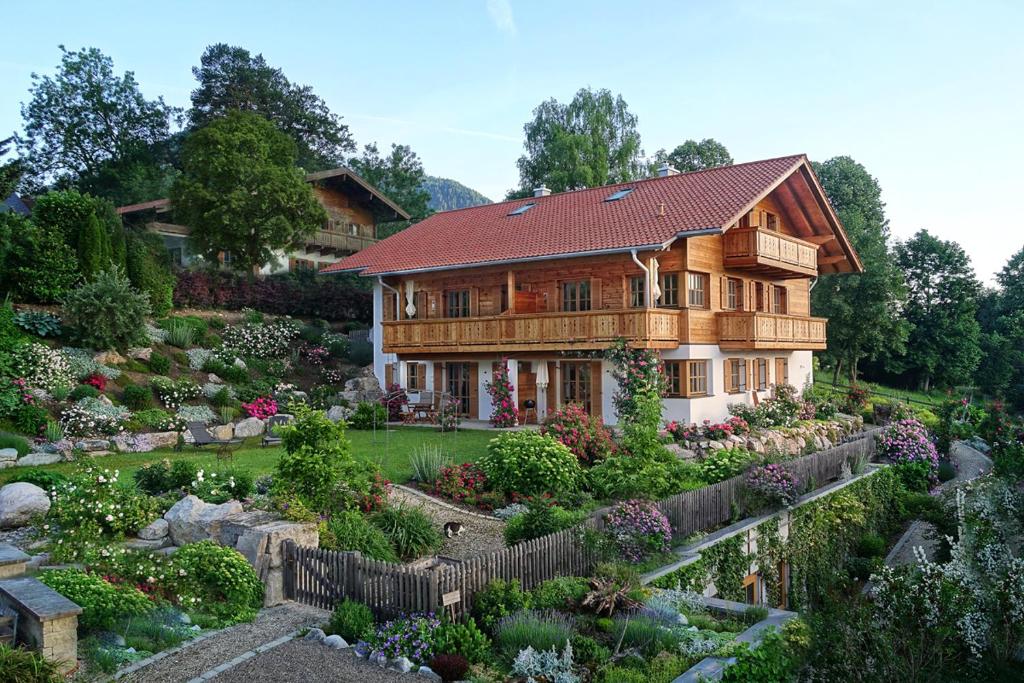 uma casa com um jardim em frente em Ferienwohnungen im Rosengarten em Ruhpolding