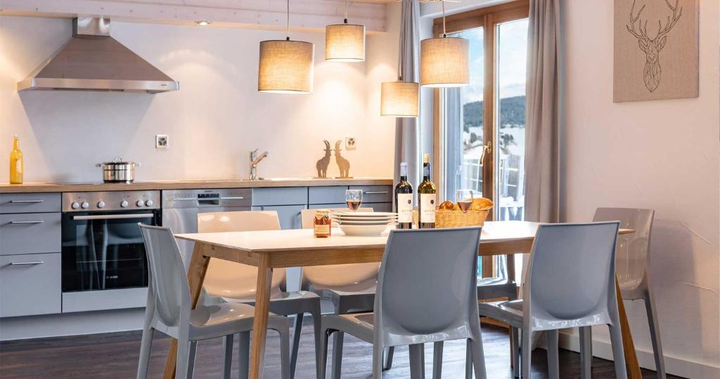 a kitchen with a wooden table and chairs at Seeblick Davos in Davos