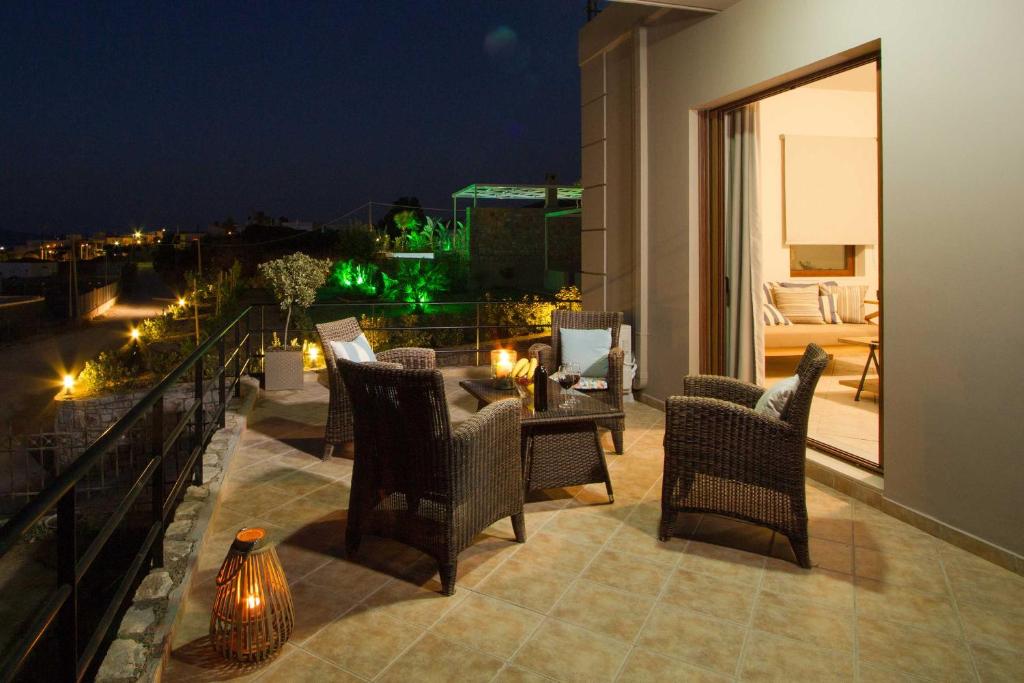 a patio with chairs and a table on a balcony at night at Mike's apartment I Luxury above the sea in Kissamos