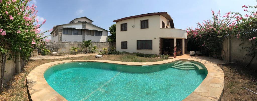 a swimming pool in front of a house at Villa Sunshine in Ukunda
