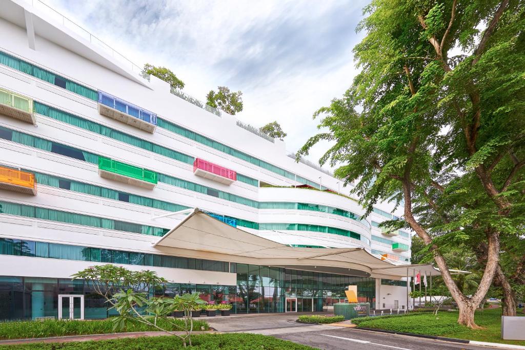新加坡的住宿－Village Hotel Changi by Far East Hospitality，一座白色的大建筑,前面有帐篷