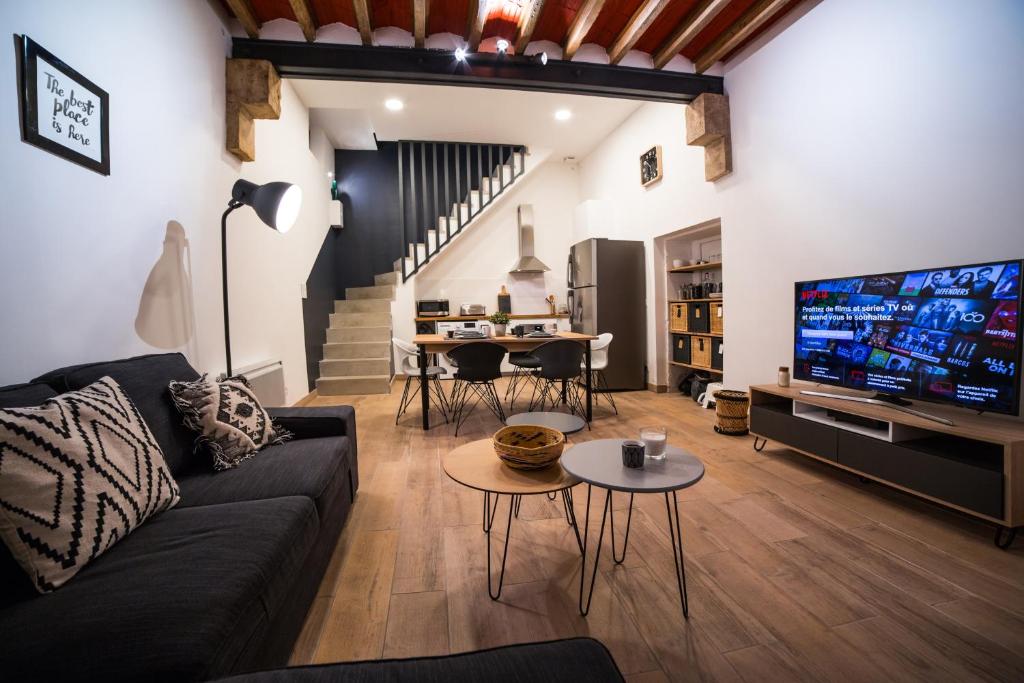 een woonkamer met een bank en een flatscreen-tv bij LGC Habitat- chambre privée- appartement commun- gare Saint-Roch in Montpellier