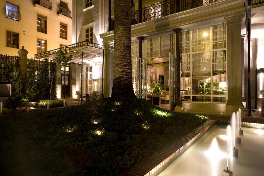 a building with a tree in a courtyard at night at Villa Oniria in Granada