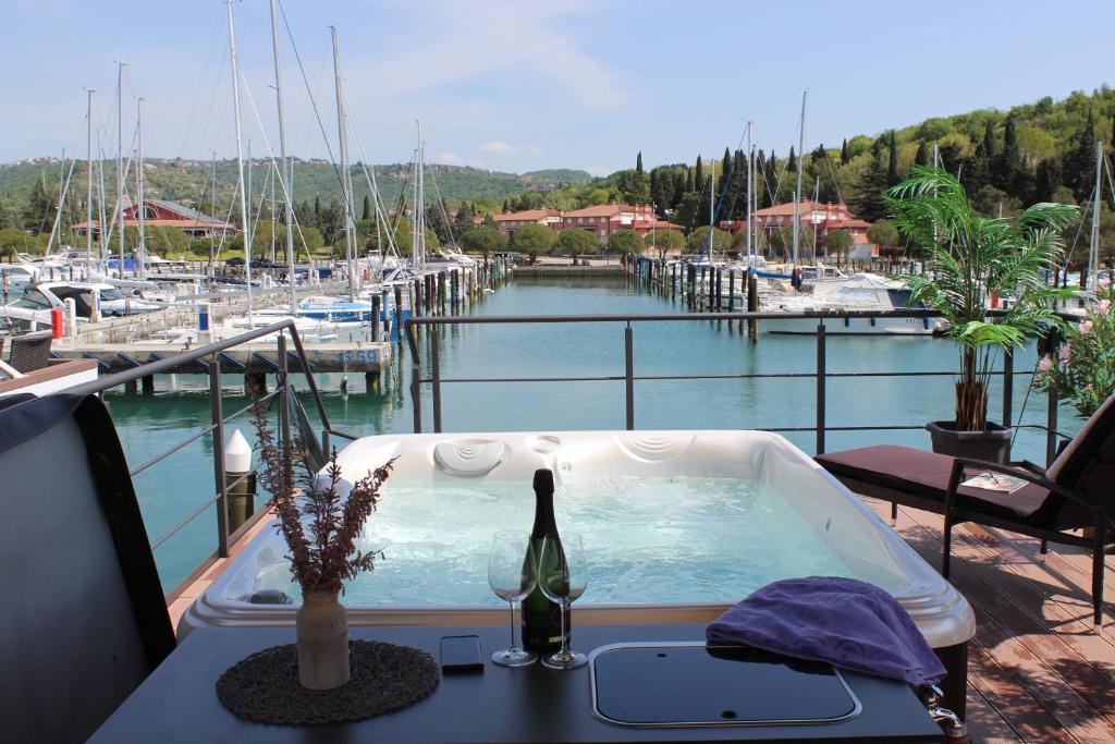 a bath tub with a bottle of wine sitting on a deck at Floating house BRAVIA in Portorož