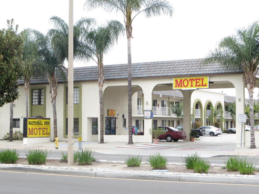 a motel on the side of a street with palm trees at National Inn Garden Grove in Anaheim