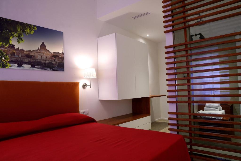 a bedroom with a red bed and white cabinets at Why Not Roma Suite in Rome