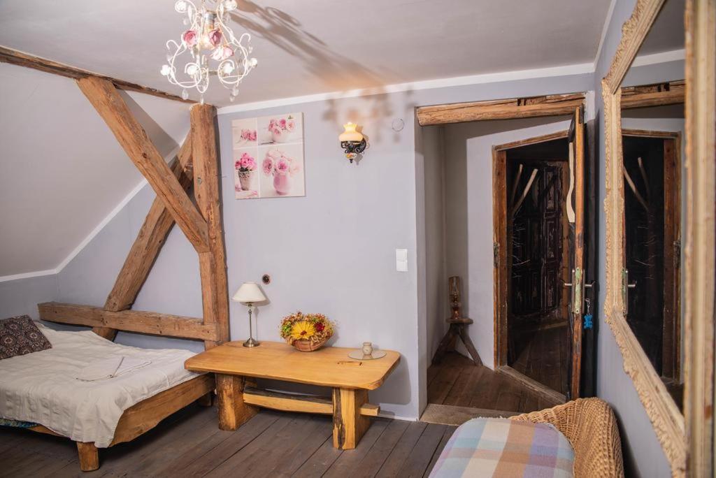 1 dormitorio con cama, mesa y lámpara de araña en Placówka - całoroczny dom wakacyjny en Wydminy
