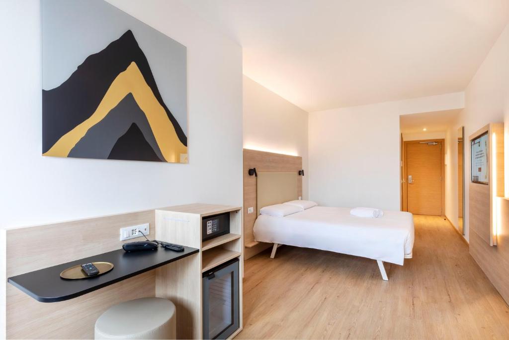 a hotel room with a bed and a desk at B&B Hotel Bolzano in Bolzano