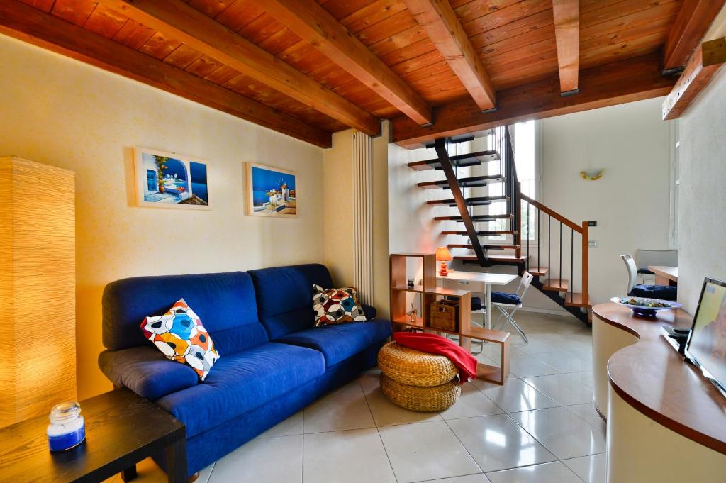 a living room with a blue couch and a staircase at UR-NEST Beverara in Bologna