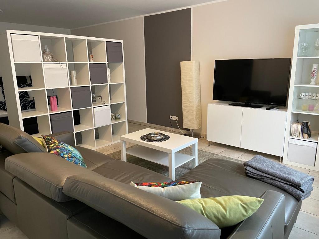 sala de estar con sofá y TV de pantalla plana en Ferienwohnung Casa Mia, en Leimen