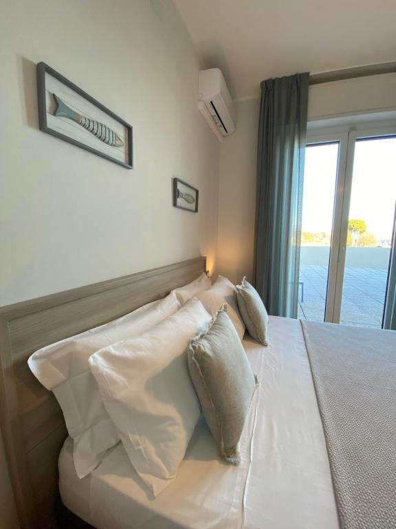 a bedroom with a bed with white sheets and pillows at Albergo La Pescatrice in Moniga