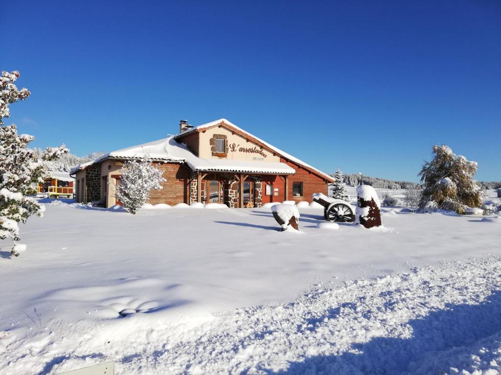 una baita di tronchi con neve a terra di L'Arrestadou a Le Bouchet-Saint-Nicolas
