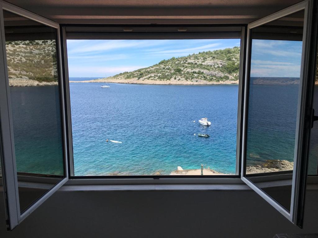 a window with a view of a body of water at Apartments puntaplanka direkt am meer in Ražanj