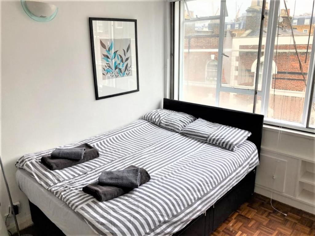 a bed with two pillows on it in a bedroom at Bright & Modern Studio flat in Paddington - Zone 1 in London