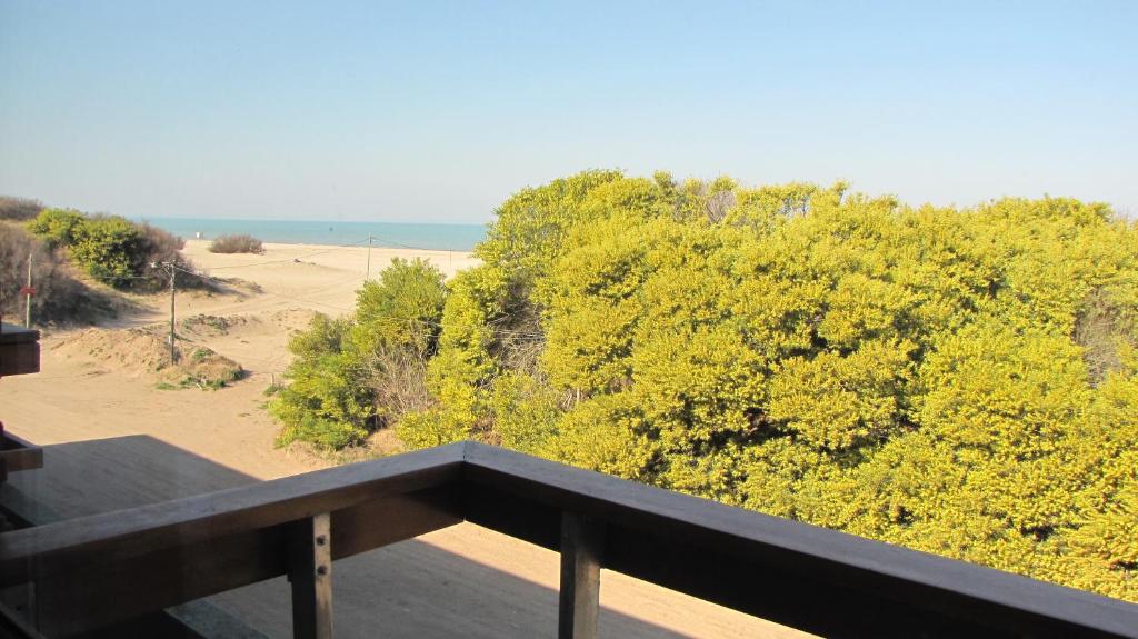a balcony with a view of a beach and trees at Departamento Villa Gesell Norte sobre Playa y 310 Vista al Mar in Villa Gesell