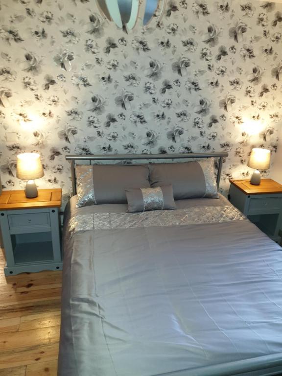 a bedroom with a bed with two night stands and two lamps at CASTLE-VIEW in Castlerock