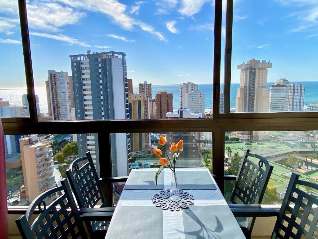 - une table avec un vase de fleurs assise sur le balcon dans l'établissement Los Gemelos 2- Aloturin Benidorm, à Benidorm