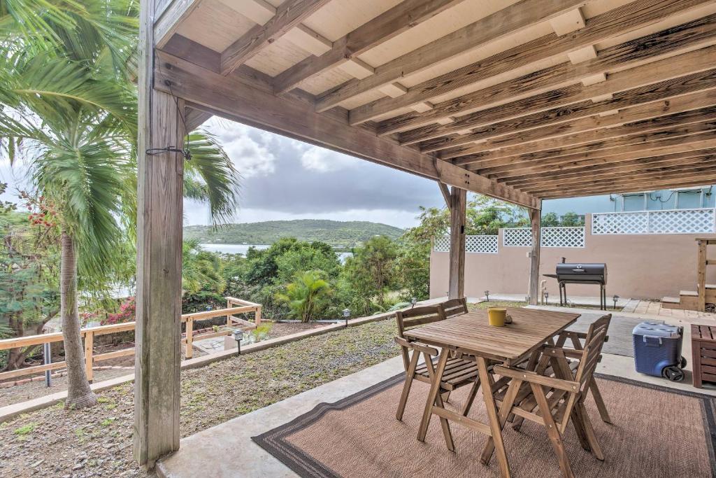 Una mesa y sillas de madera en un patio con vista. en Culebra Bungalow with Bay Views and Modern Amenities!, en Culebra