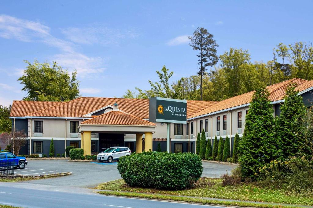 a hotel with a car parked in a parking lot at La Quinta Inn by Wyndham Radford in Radford