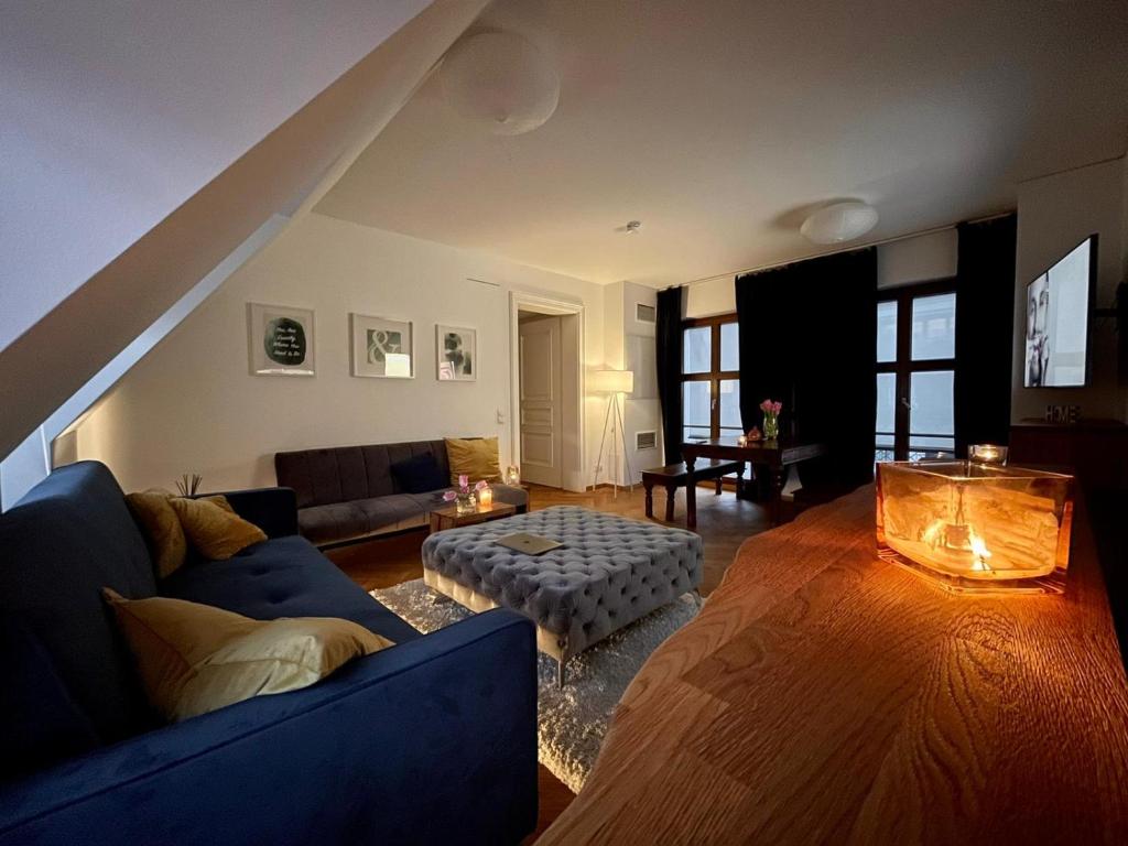 a living room with a blue couch and a table at Modernes Apartment an der Frauenkirche in Dresden