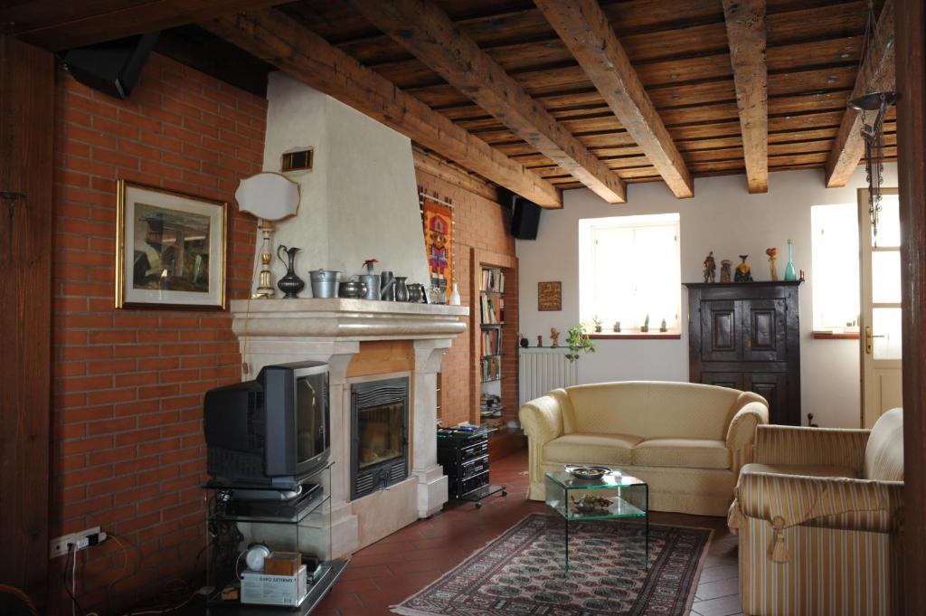 ein Wohnzimmer mit einem Kamin und einem TV in der Unterkunft Bed & Breakfast Pegaso in Valeggio sul Mincio