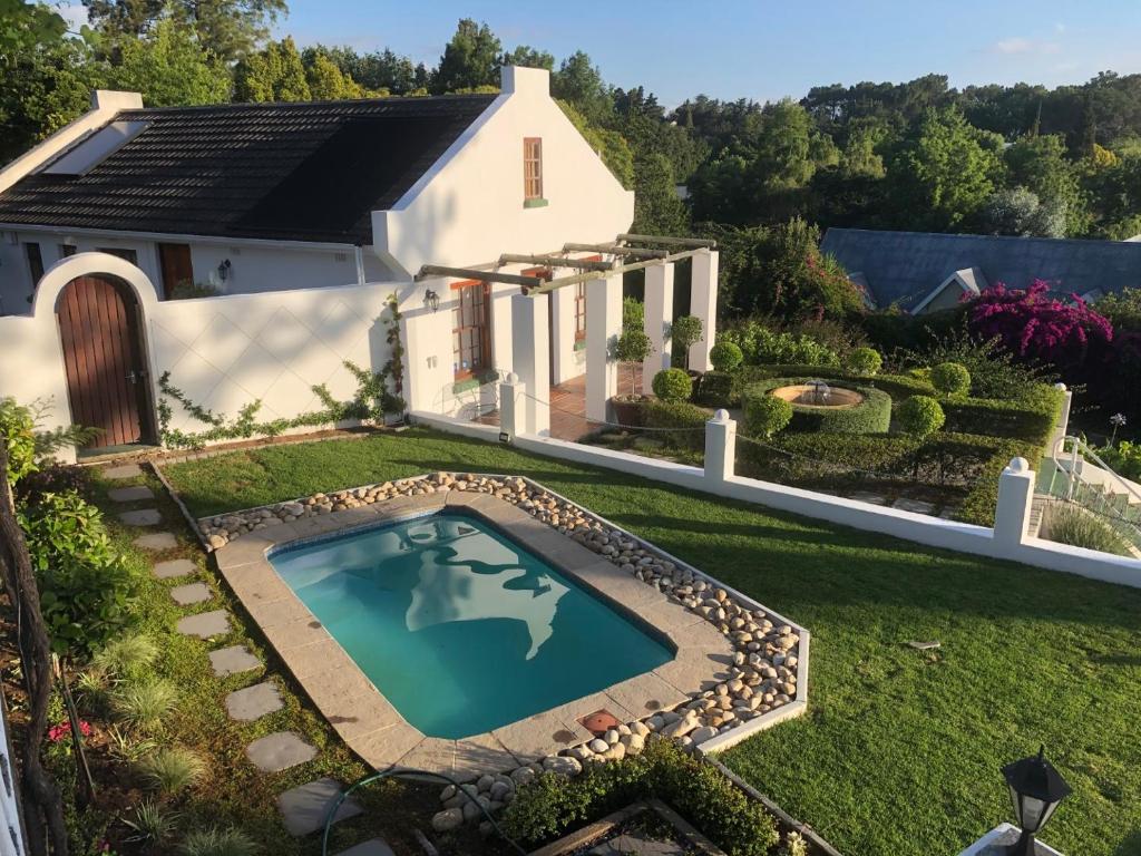 - une vue aérienne sur une maison avec une piscine dans la cour dans l'établissement Somerset Grace Cottage, à Somerset West